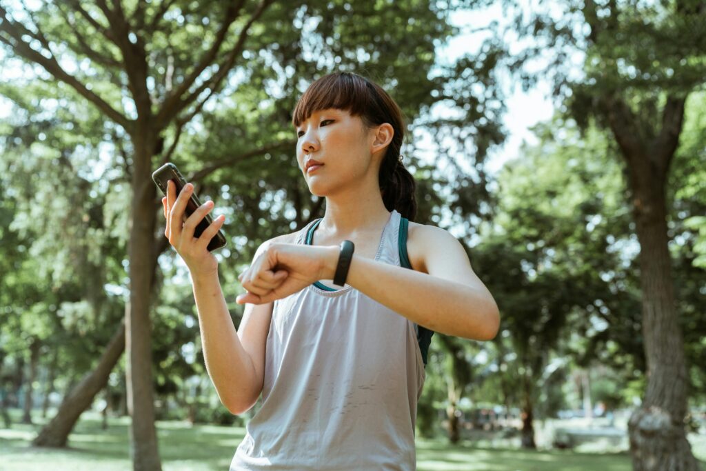 A woman looking at her phone and a watch